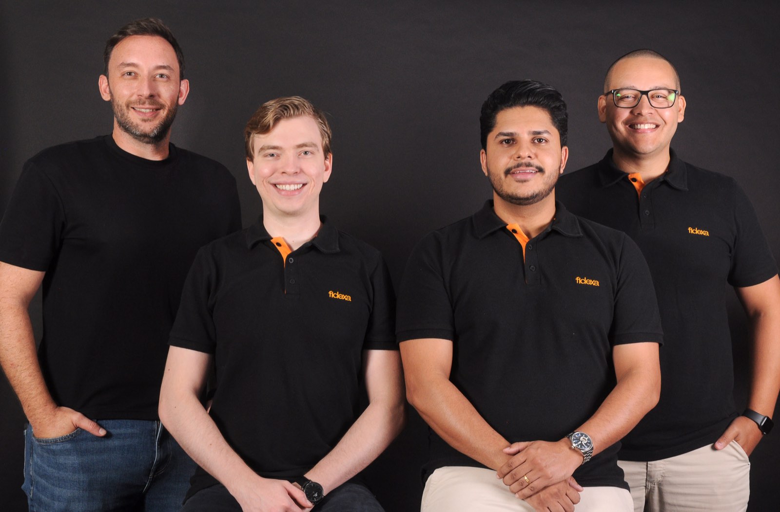 Os quatro fundadores da Fidexa lado a lado, de camisa preta com o logo da empresa